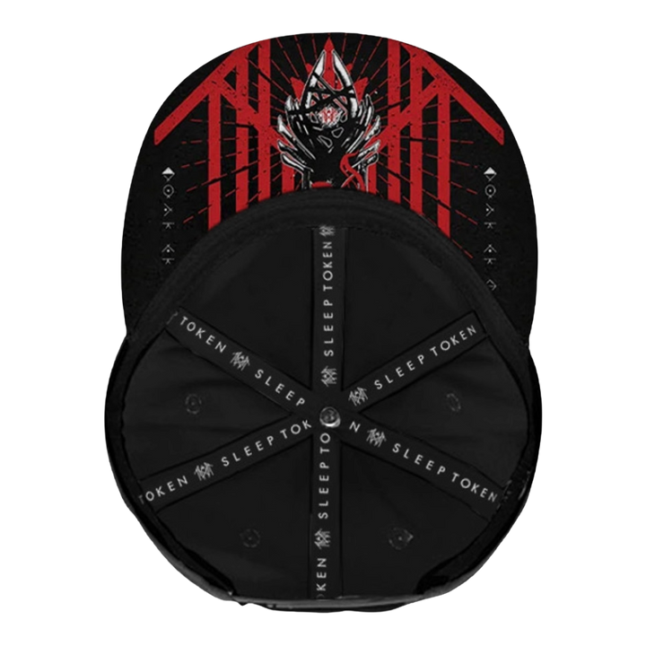 A black baseball cap shown from the front, featuring a red and black graphic design on the crown with a stylized horned figure and the word 'TOKEN' repeated on the black adjustable underbraces.
