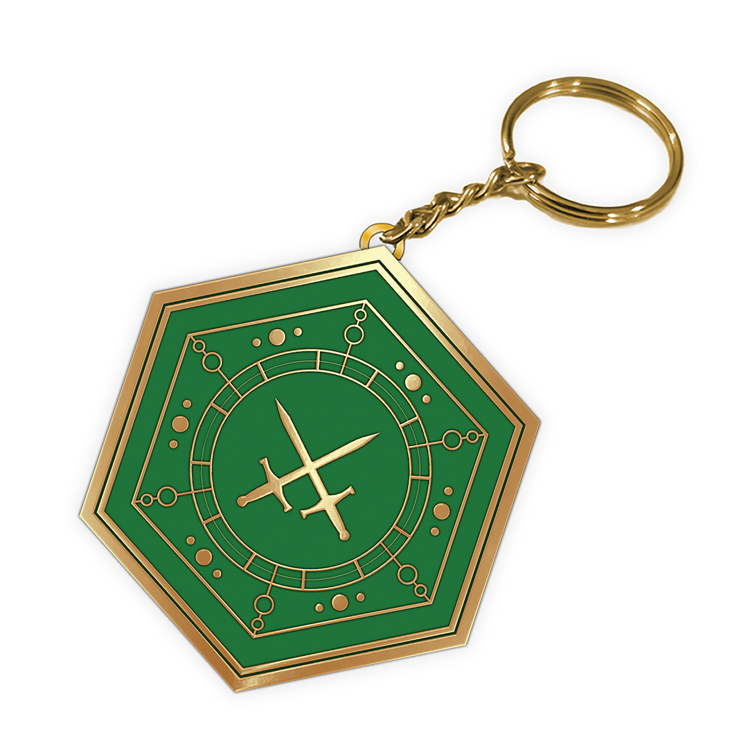 A hexagonal keychain featuring a green and gold design with a central crossed swords symbol and circular emblem, attached to a gold split ring and chain on a white background.